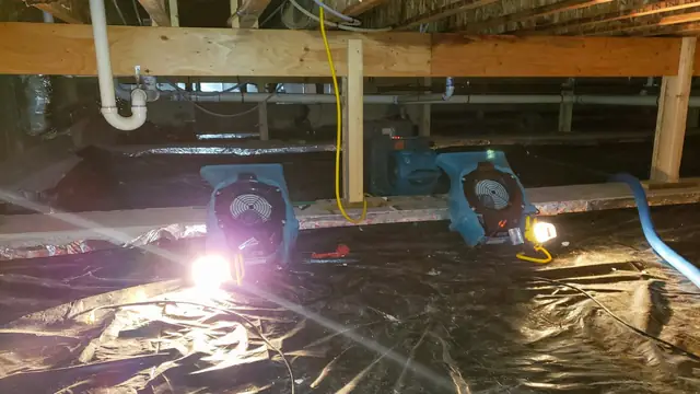 Drying fans running in a lower-level crawl space with plastic sheeting
