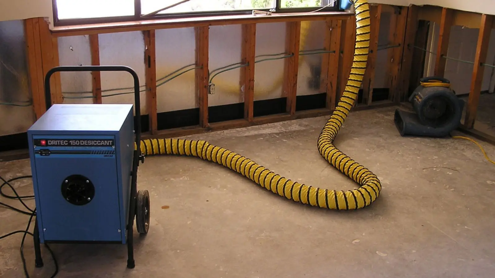 Dehumidifier and ducting drying a room where wall sections were removed